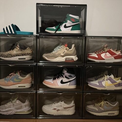 Tien zwarte sneakerdisplayboxen in een piramidevormige opstelling van drie rijen, gevuld met diverse Nike-, Jordan- en Adidas-modellen, tegen een witte muur.